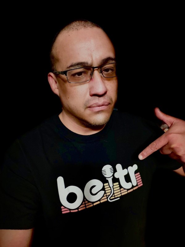 The founder of Beltr, pointing at his Beltr shirt